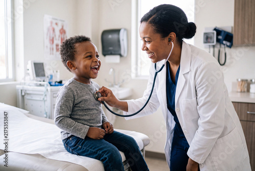 Happy Pediatrician Examines Laughing Little Boy with Stethoscope in Clinic