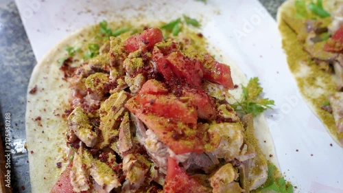 Spiced traditional Turkish sogus ingredients with tomatoes on flatbread