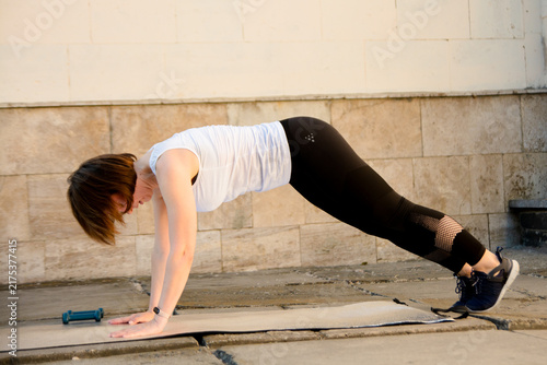 Photography Fit woman doing core strengthening plank exercise outdoors on a yoga mat