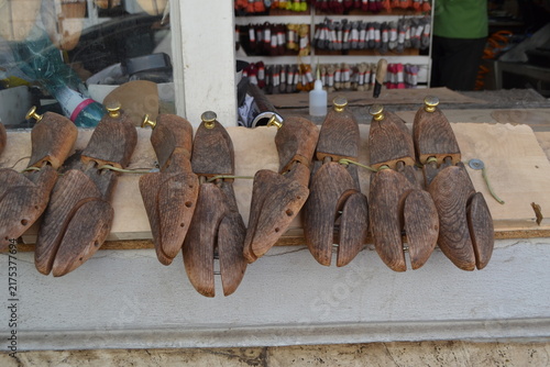 Fotografie Multiple wooden shoe lasts lined on a board at a cobbler shop counter for craft