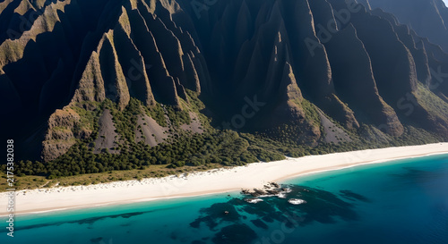 Coastal mountain range and sandy beach with clear turquoise water view