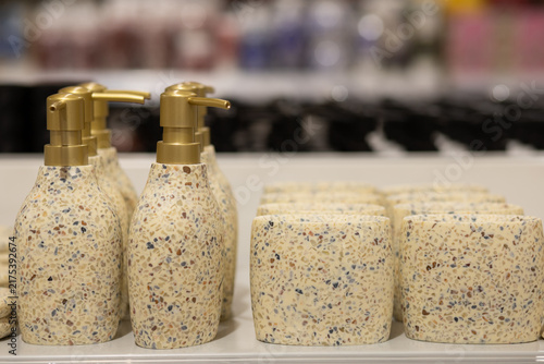 Closeup Of Gold Dispenser Pumps On White Honeycomb Bottles.