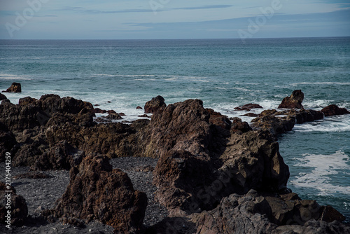 rugged coastal rocks against a vast ocean backdrop under a clear sky