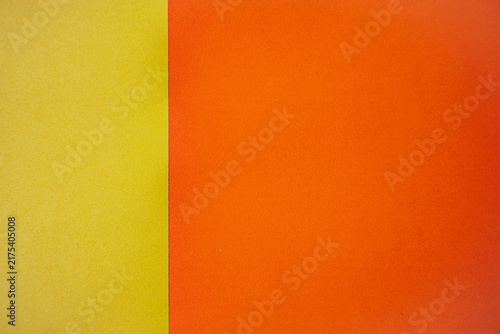 Bright yellow and orange textured paper sheets side by side, showcasing vibrant colors and smooth surfaces suitable for various creative projects and design applications