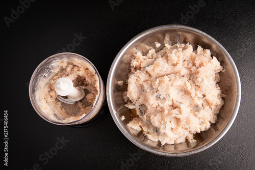 Canvastavla Raw minced fish in metal bowl and blender cup top view