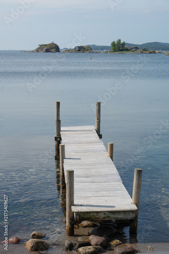 A wood pier on a sunny summer day along the coast of Norway.