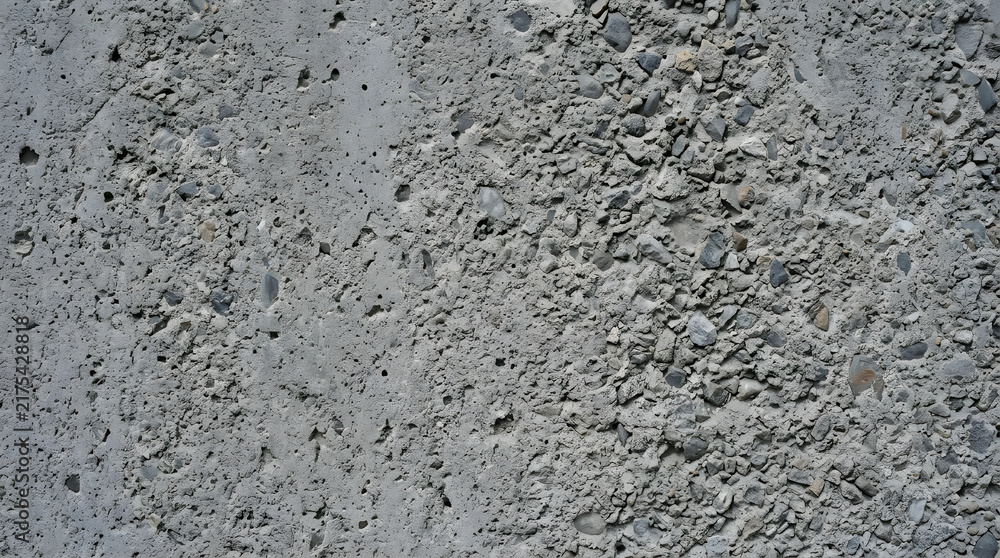 Fototapeta premium Industrial concrete texture with rough stone aggregate. Weathered cement wall background. Gritty gray construction surface for architectural design.
