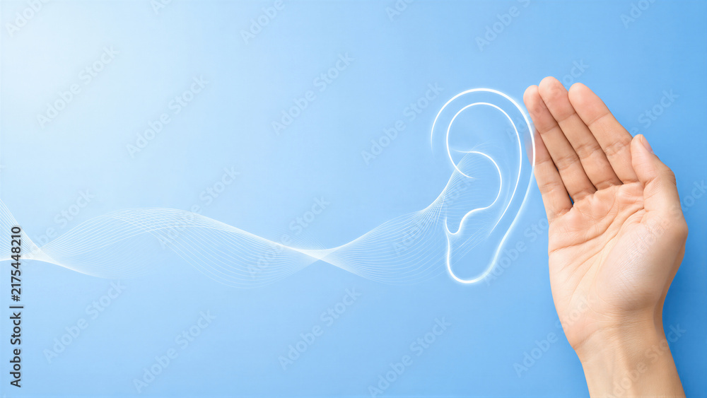 Obraz premium Woman hand cupped near glowing digital ear with sound waves on blue background. Hearing loss and deafness awareness concept for International Deaf Day. Audiology and ear care.