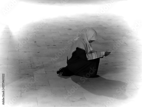Muslim Woman Kneeling in Prayer Wearing Hijab Showing Devotion and Quiet Contemplation