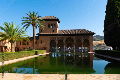 the Palacio del Partal (Partal Palace) and its large reflecting pool inside the historic Alhambra fortress in Granada, Spain.