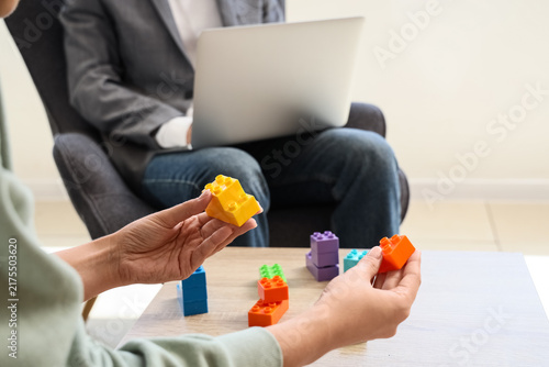 Cuadro en lienzo Child development and play therapy, therapist observing child building with colo