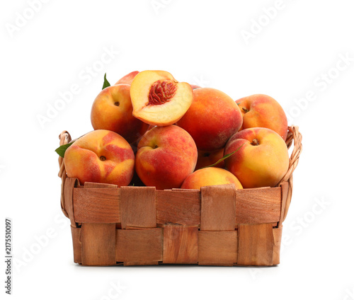 Konstfotografi Wicker basket with sweet ripe peaches on white background