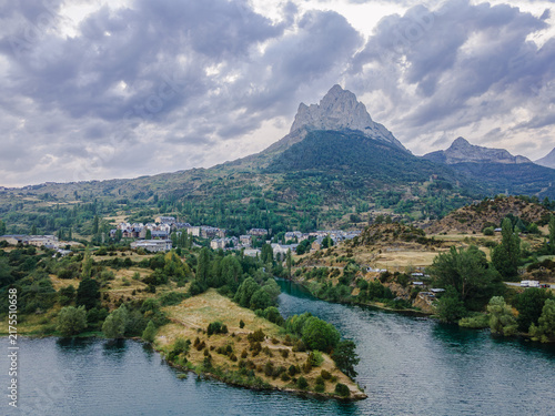 Cuadro en lienzo Aerial view of a mountain village and the turquoise reservoir with the Pena Foratata peak beyond in the Spanish Pyrenees Aragon a scenic and majestic landscape evoking freedom and wanderlust