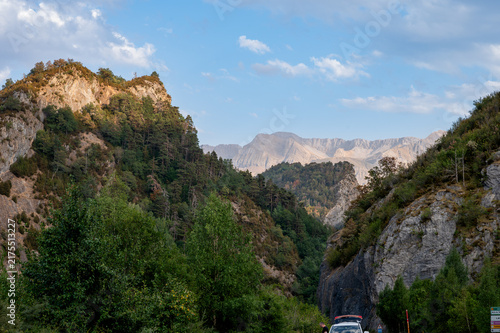 Fotografie A rocky crag and the rugged peaks of the Spanish Pyrenees glow in the evening light near Formigal Spain a wild and dramatic mountain landscape evoking adventure and the call of the summits