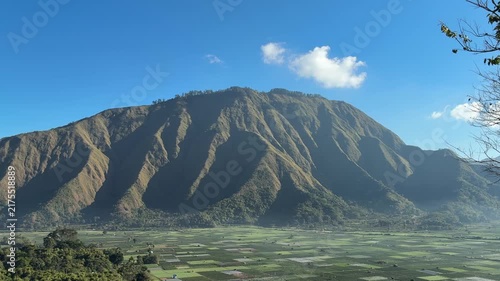 Dramatic Green Mountain Ridge Under a Blue Sky
