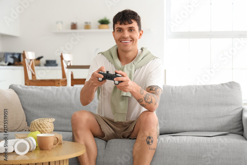 Young man playing video game on sofa at home