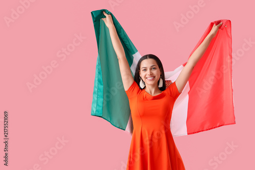 Young woman with Mexican flag on pink background