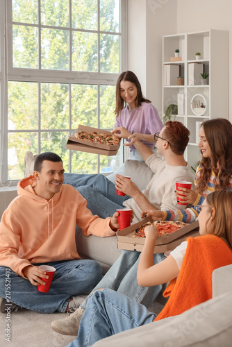 Group of young friends with beer and pizza at home party