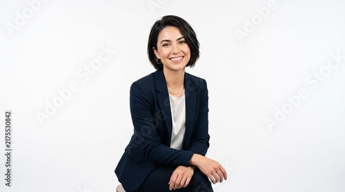 Confident young professional woman smiling in navy blazer on white background