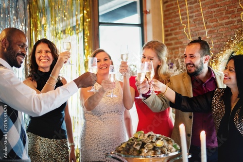 Foto Diverse group of men and women toasting champagne at a festive party