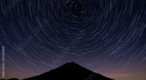 Star trails over mountain at night.