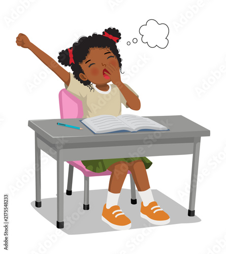 Little African girl yawning feeling sleepy while studying doing homework at the desk