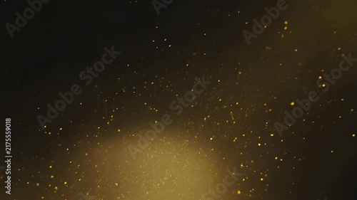 Golden dust particles floating and glowing in bright light beam against dark background
