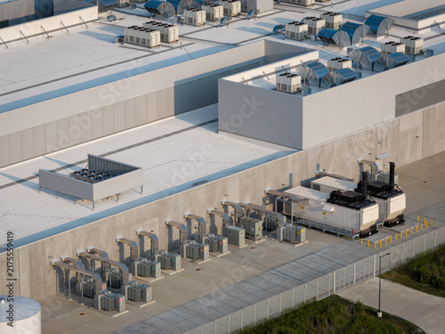 Aerial view of data center facility with cooling units and surrounding industrial infrastructure	