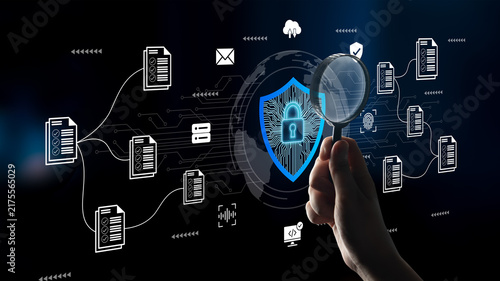 Fotografie Illustration of a hand holding a magnifying glass over a shield symbol, representing digital security and data protection in a computerized environment with interconnected files