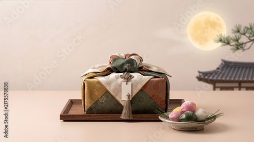 Traditional Korean Chuseok Gift Box Wrapped in Silk Bojagi with Songpyeon and Full Moon 한국 전통 명절 추석 학자수 보자기 선물 포장과 송편 및 도자기 다기세트 배경