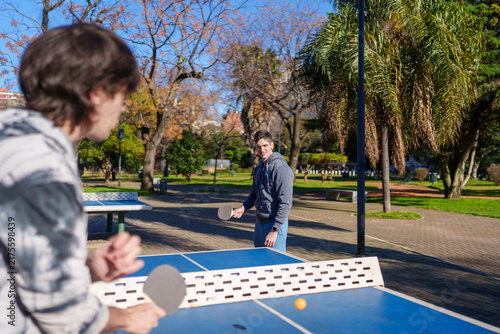 Young men playing table tennis in park
