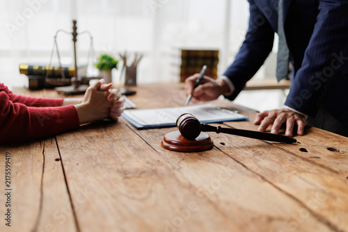Canvas Print Legal professional reviewing a contract with a client at a wooden desk, offering