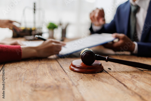 Konstfotografi Gavel on wooden desk with client signing legal document, lawyer advising on cont