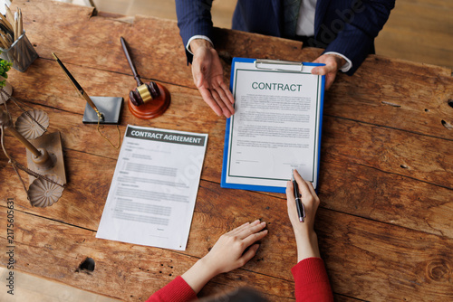 Foto Client signing a legal contract agreement with a lawyer, reviewing paperwork and
