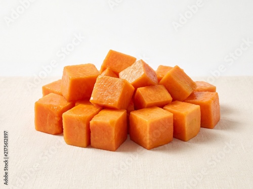 Fresh organic papaya cubes stacked on a cloth surface