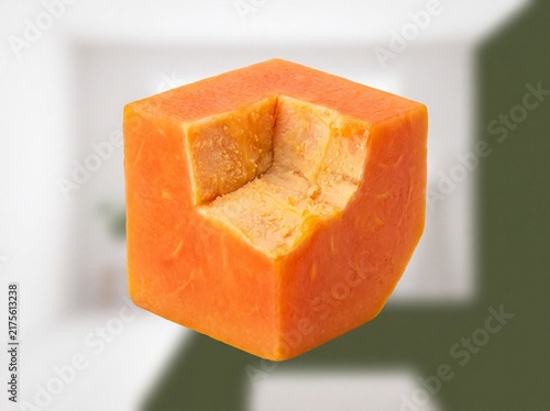 Fresh papaya cubes floating on blurred kitchen background