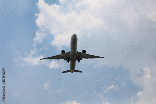Canvastavla Commercial jetliner flying overhead against a cloudy blue sky
