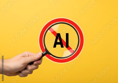 Hand holding a magnifying glass over a red prohibition sign with the letters ai on yellow