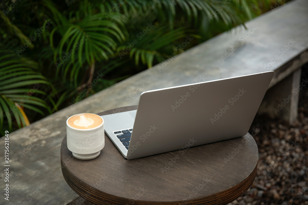 Obraz premium A freelancer enjoys coffee while working on a laptop outdoors