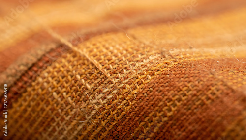 Macro Close Up of Textured Woven Fabric Background with Warm Orange and Brown Fibers