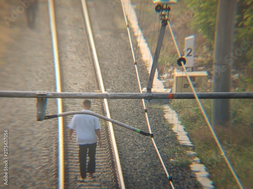 high angle view of someone walking along railway tracks in the warm morning light