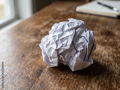 Crumpled Paper Ball Resting on a Rustic Wooden Table