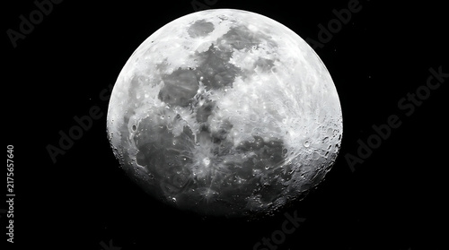 A bright gibbous moon illuminated against the dark void of deep outer space