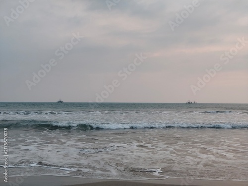 Картината върху платно Moody seascape with gentle ocean waves under cloudy twilight sky