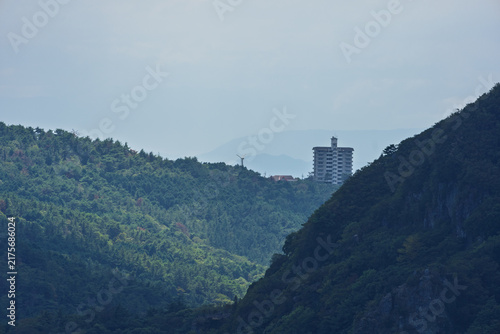 Lone abandoned apartment building on forested mountain