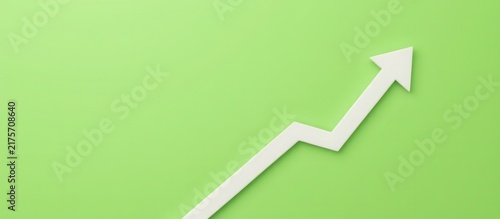 White upward arrow graph on green background symbolizing growth and progress.