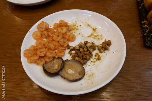 Принти на полотні Seasoned peeled shrimps served with cooked shiitake mushrooms on a white ceramic plate
