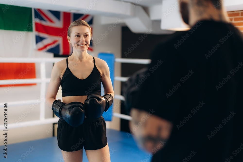Obraz premium Woman boxer training with coach in ring