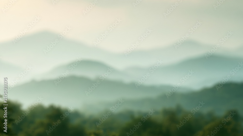 Obraz premium Fog covers green hills in the morning, creating a blurred view of the landscape with vast open space for imagination.