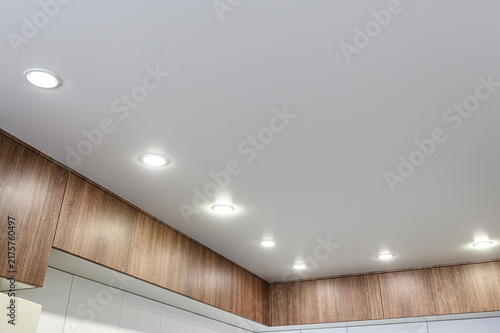 Fotografie White matte ceiling with evenly spaced recessed LED spotlights